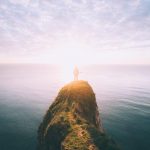 Homme seul devant la mer face au soleil