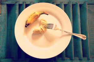 Banane écrasée à la fourchette et assiette blanche